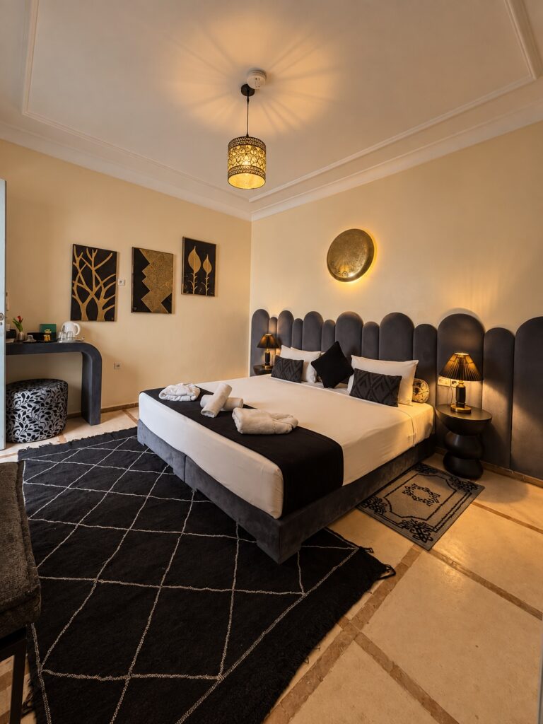 Vue d’ensemble de la chambre Alaouites avec lit double et tête de lit grise