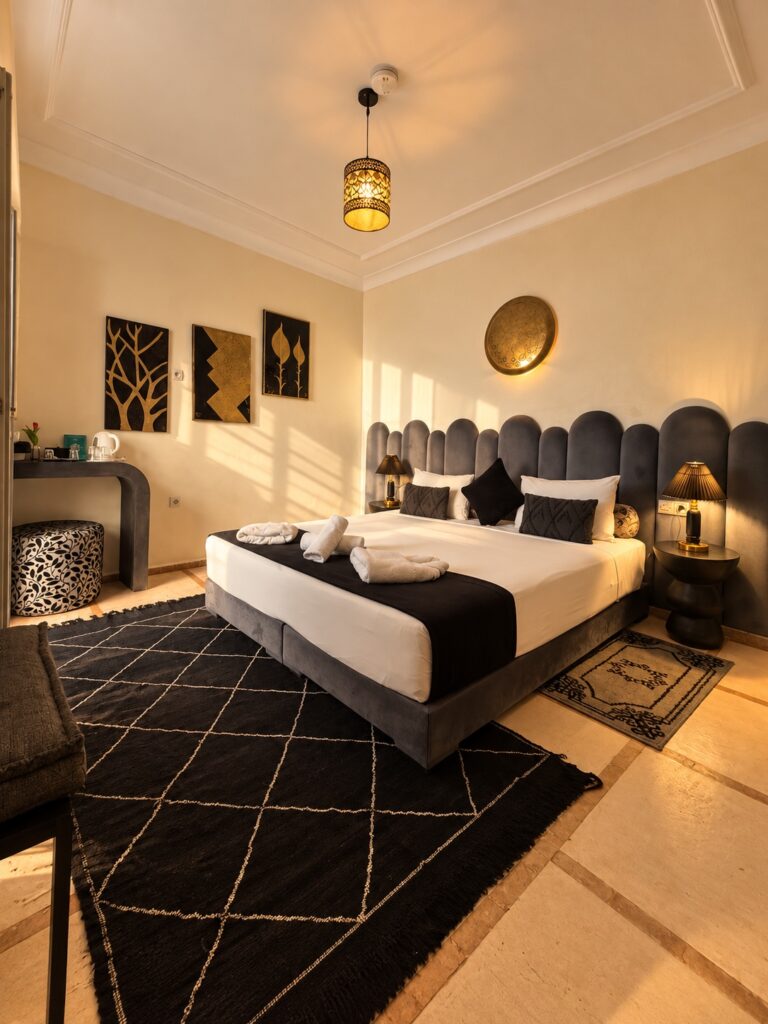 Chambre Alaouites du Riad Dar Chadia, lit double et décoration noire et dorée en lumière naturelle