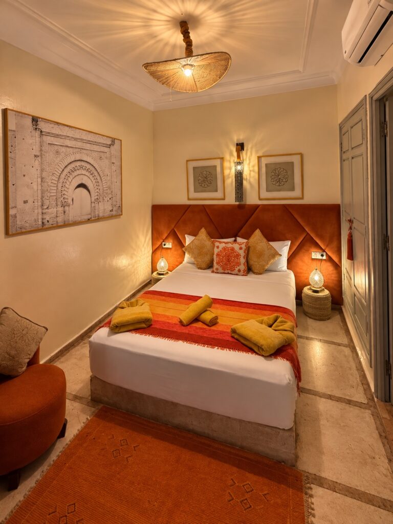 Chambre Almohades au Riad Dar Chadia : lit double, tête de lit terracotta et décoration marocaine.