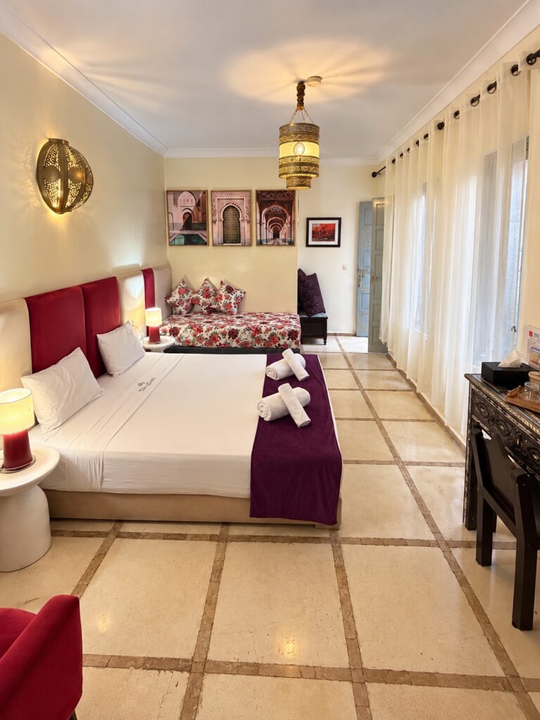 Chambre Saadiens avec banquette fleurie, bureau et rideaux blancs