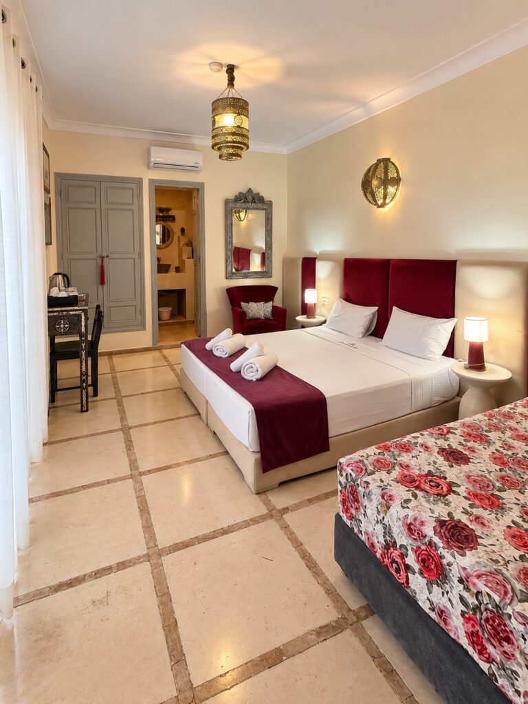 Vue d’ensemble de la chambre Saadiens avec fauteuil et accès à la salle de bains