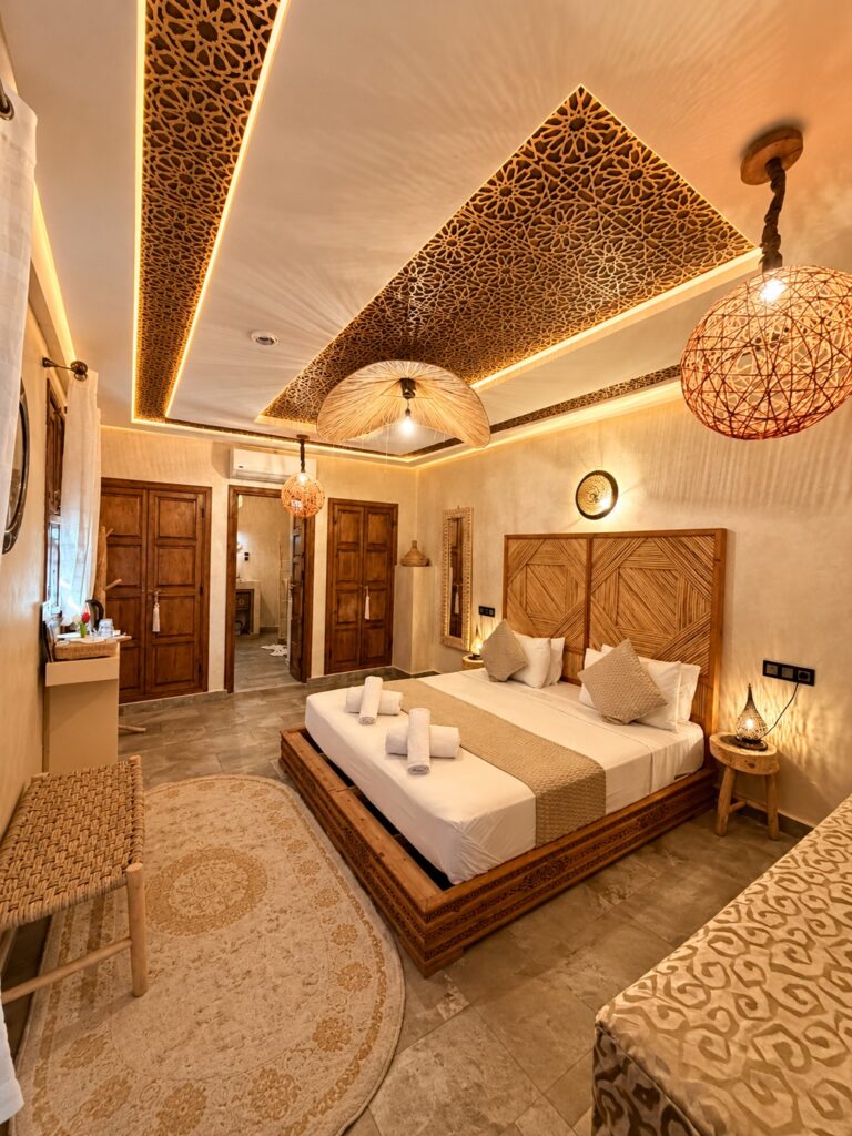 Vue d’ensemble de la Suite Dorée avec mobilier en bois et luminaires tressés