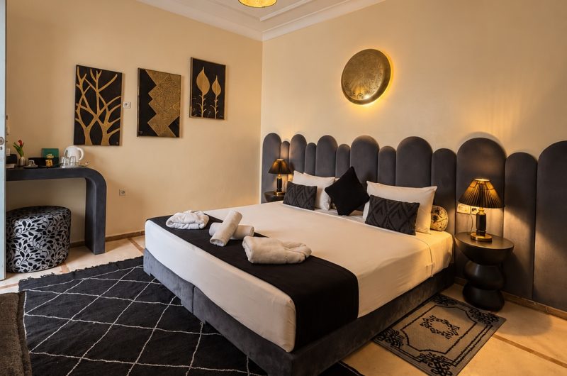 Vue d’ensemble de la chambre Alaouites avec lit double et tête de lit grise