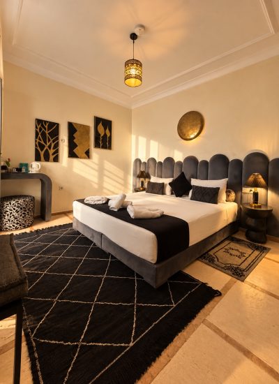 Chambre Alaouites du Riad Dar Chadia, lit double et décoration noire et dorée en lumière naturelle