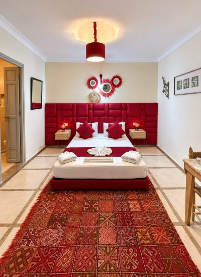 Vue d’ensemble de la chambre Mérinides avec tapis à motifs et coin bureau