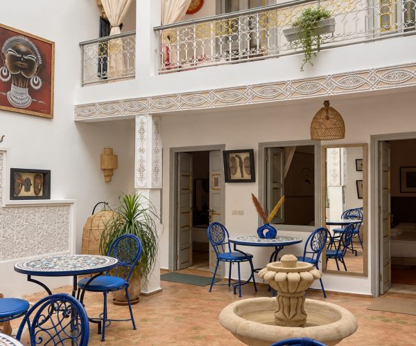 Patio lumineux du Riad Dar Chadia avec fontaine et mobilier bleu