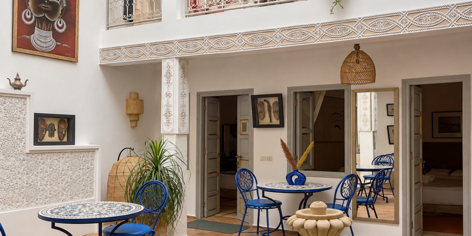 Patio lumineux du Riad Dar Chadia avec fontaine et mobilier bleu