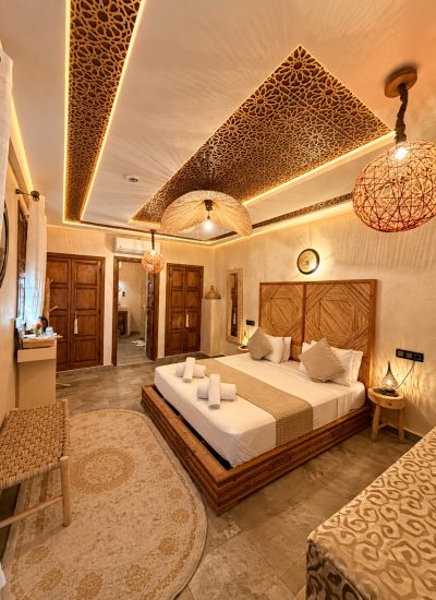 Vue d’ensemble de la Suite Dorée avec mobilier en bois et luminaires tressés